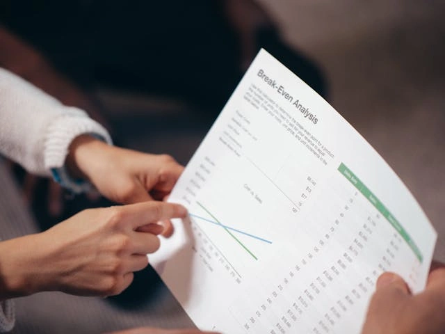 Liikemiehet keskustelemassa suunnitelmasta, korostaen osakeyhtiön lopettamisen hintaa strategiseen päätöksentekoon